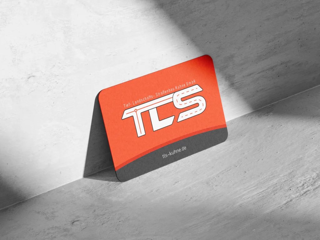 Visitenkarte der TLS Kuhne GmbH in kräftigem Orange mit weißem Logo und Straßenmotiv auf strukturierter Oberfläche